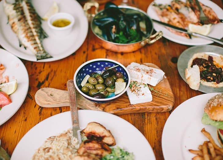 Intimate kosher dining table with freshly prepared fish and shared dishes